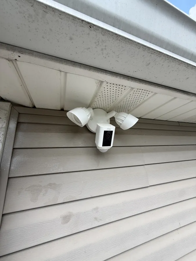 Ring floodlight camera mounted under an eave